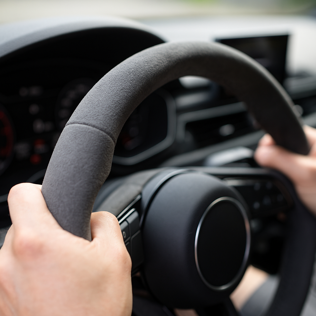 Driver hands on microfibre steering wheel cover showing grip texture for best steering wheel covers UK 2026