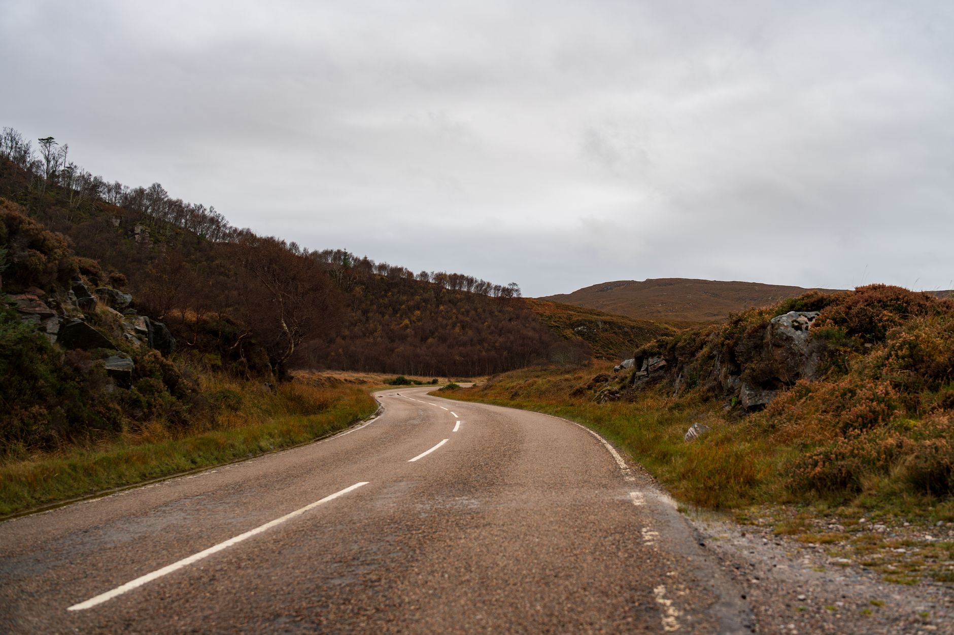 Single-track coastal road on the Applecross Peninsula driving route Scotland with passing place sign