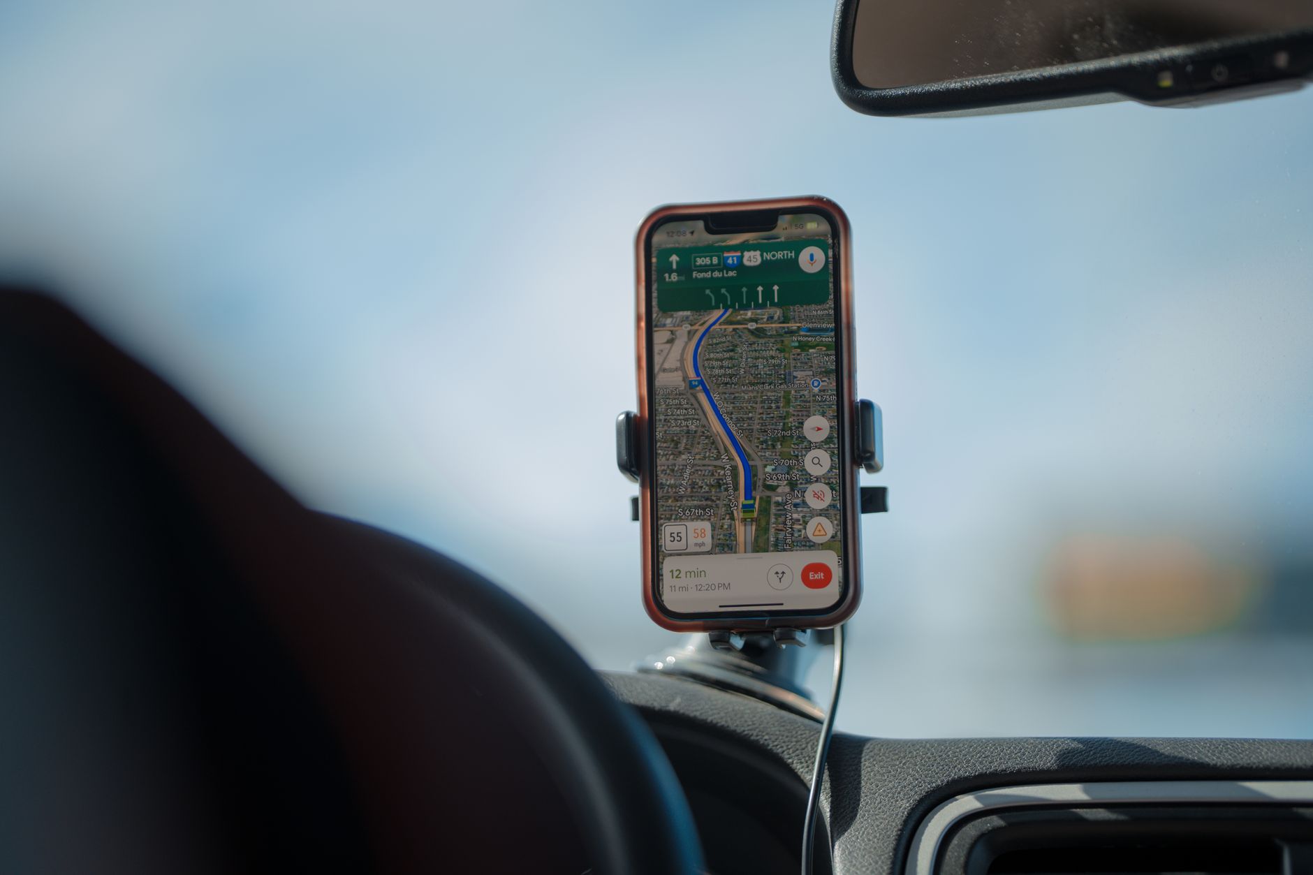 Smartphone in car vent mount showing navigation app — sat nav vs phone navigation UK